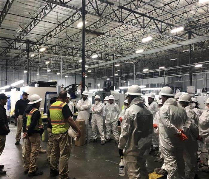 uniformed crew meeting in a warehouse
